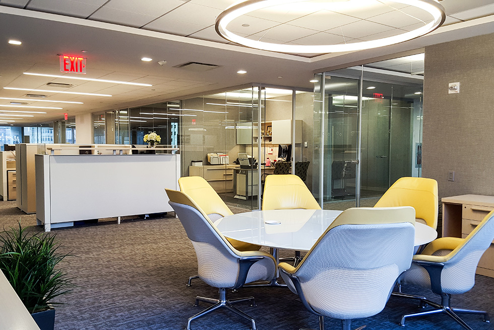 Milk glass table within the open office area provides for informal meetings and working sessions. 